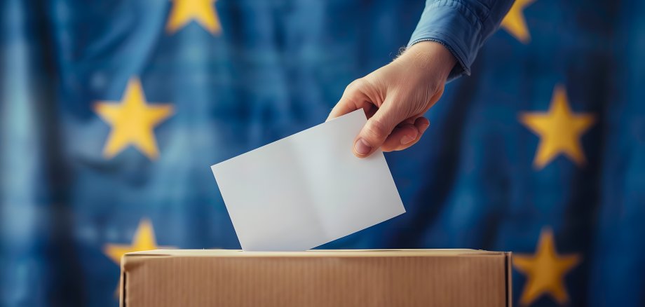 Voting concept - Ballot box on the European Union flag background. Election in European Union. Woman putting her vote in the ballot box.